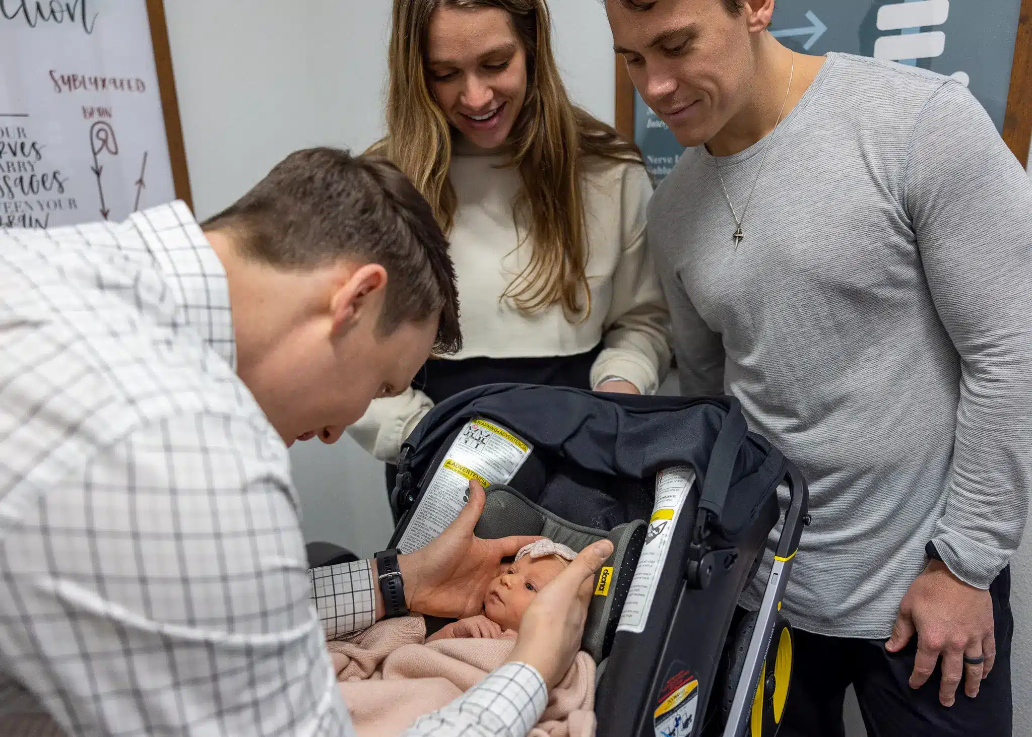 ICPA-certified pediatric chiropractor gently checking a newborn baby&rsquo;s spine at Restoration Chiropractic in Prosper, TX
