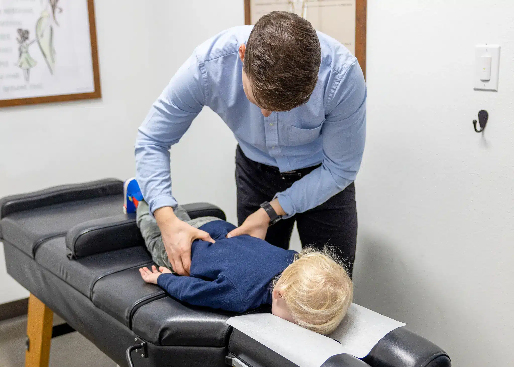 Toddler receiving a gentle pediatric chiropractic adjustment at Restoration Chiropractic in Prosper, TX