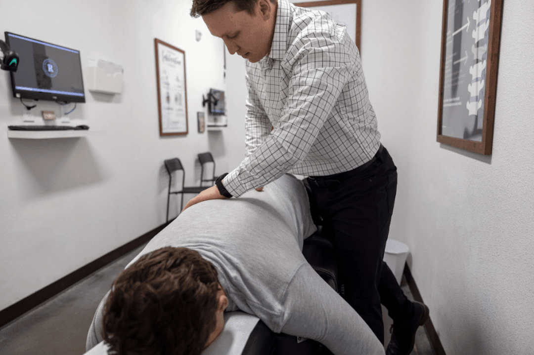 Gentle, instrument-based chiropractic adjustment for a herniated disc patient at Restoration Chiropractic in Prosper, TX