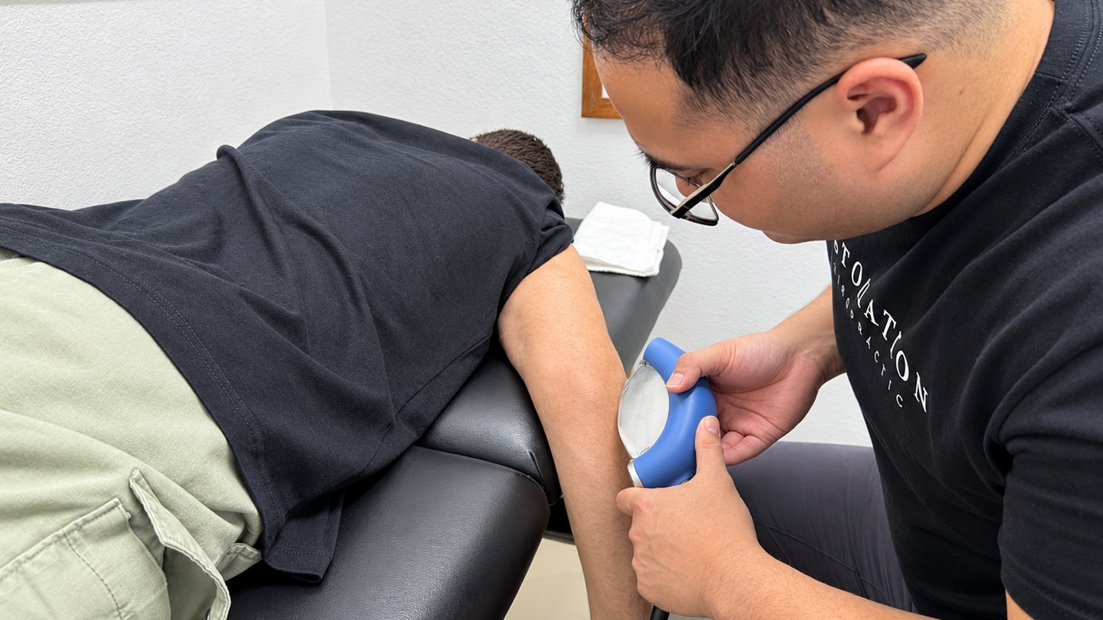 Restoration Chiropractic team member treating a patient&rsquo;s elbow with PiezoWave shockwave therapy in Prosper, TX